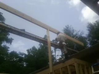 Carpenter setting a ridge beam over a new addition frame — Ice Dam Removal by Roofing Brothers in Roosevelt